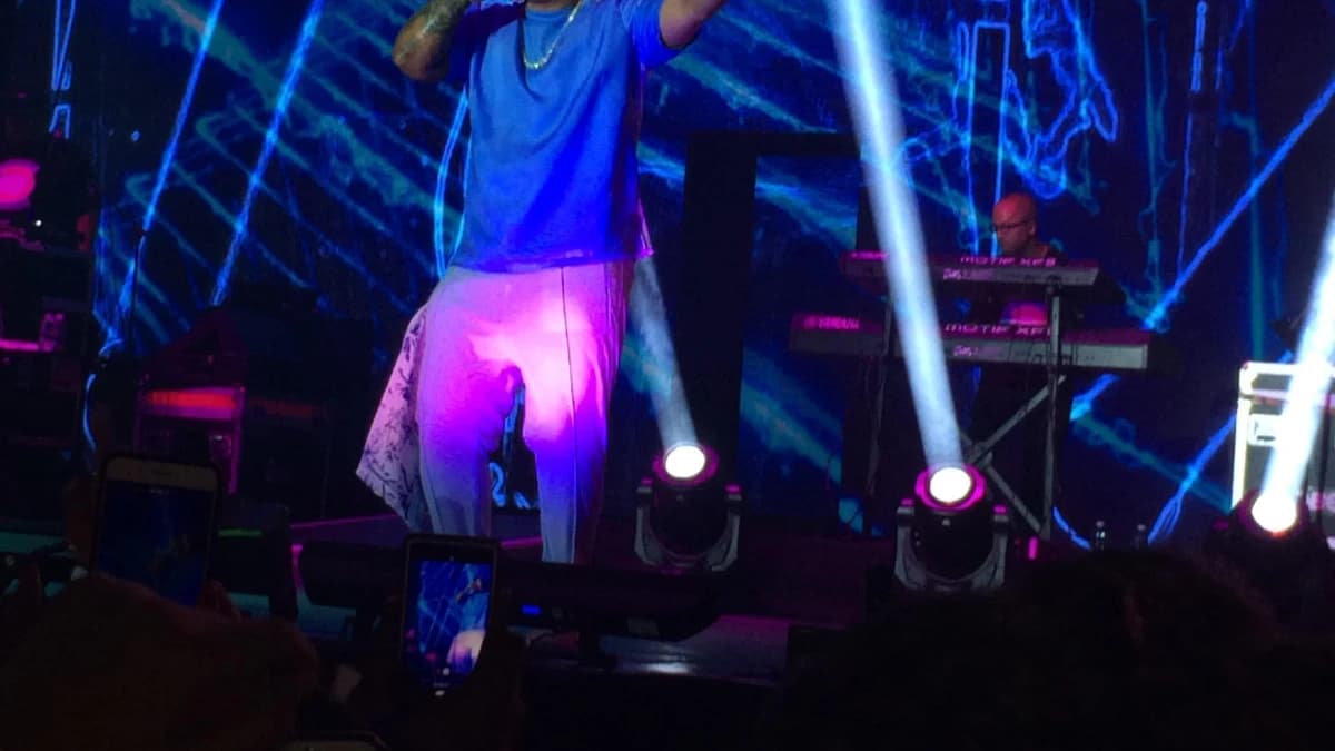 Daddy Yankee performing under blue stage lasers on the Con Calma Tour in 2019